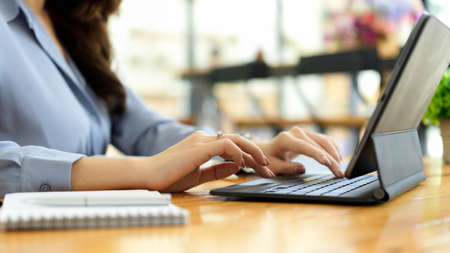 Businesswoman using portable tablet, typing on portable keyboard at coffee shopの写真素材