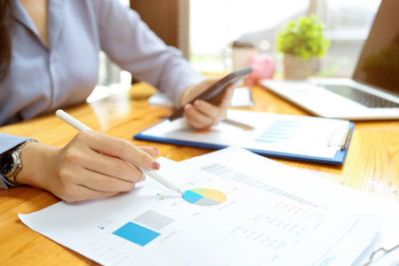 Closeup, Businesswoman analysing cost by looking on a financial chart, business worker, financial workerの写真素材