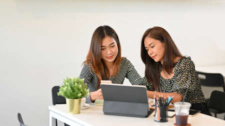 Businesswomen startup working together, discuss business solutions, brainstorm business strategy, sitting in co-working spaceの写真素材