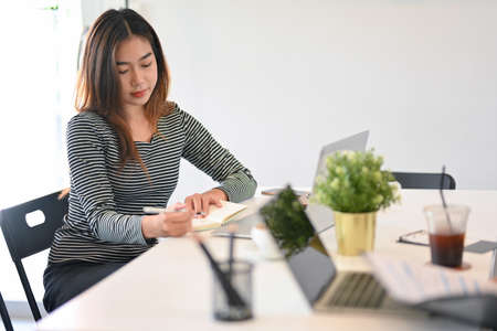 Businesswoman taking notes on notebooks, checking business meeting in schedule book, assistant...