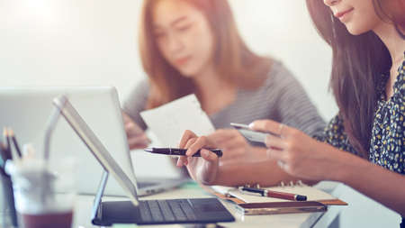 Business-finance concept, cropped of attractive female using credit card to pay on online shopping, transferring money via tablet at office, blurred office in backgroundの写真素材