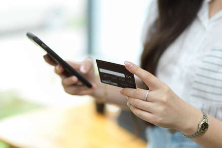Close up, Businesswoman using mobile phone and holding credit card for online payment, online payment user, online shopping, money transferの写真素材