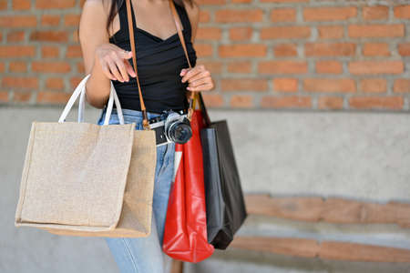 Shopping concept, Attractive female holding shopping bags, shopping along the street, lifestyles, close upの写真素材