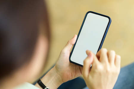Smartphone blank screen mockup using by female with blurred background, mockup for application banner, close upの写真素材