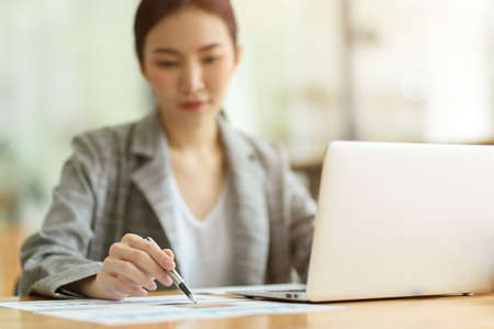Selective focus image, businesswomen working in office, thoughtful and pensive thinking about business financial with financial reportの写真素材