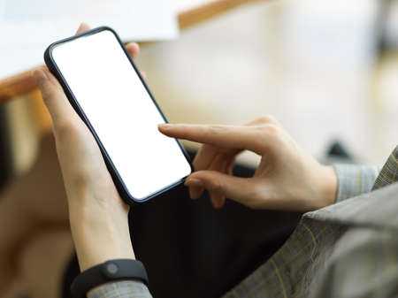 Businesswoman using mobile phone at office, female hands holding smartphone. text, message, watch video, online shopping, planning agenda. phone mockupの写真素材