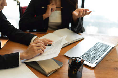 Cropped shot of businessman and businesswoman discussing the data result on paper report in workplace. working together conceptの写真素材