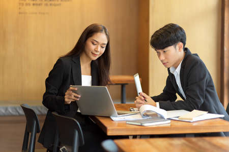 Young businesswoman consulting, giving business instruction, presenting business strategy to her team in officeの写真素材