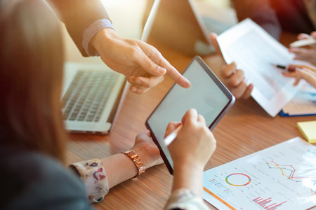 Cropped image of business team planning business strategy together on digital portable tablet in meeting room. tablet mockupの写真素材
