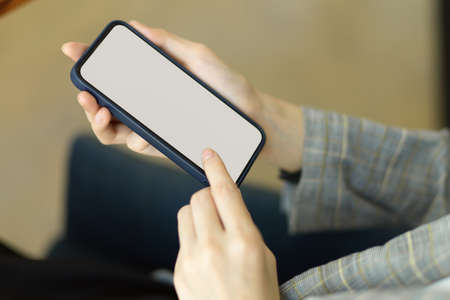 Closeup focus hands using smart mobile phone to communicate with colleagues, mobile phone blank screen mockupの写真素材