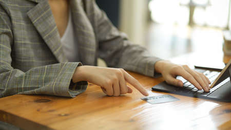 Cropped closeup hands image, Woman in casual suit using portable tablet for online payment. cashless, transfer money, credit card.の写真素材
