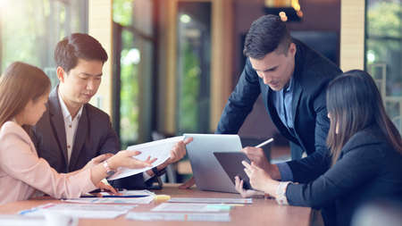 A diverse group of business people focused intently on a business project, working together in conference room. Teamwork conceptの写真素材
