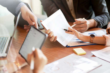 Cropped image of a professional business team working together on a research project, brainstorming, and formulating business solutions.の写真素材