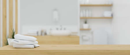 Wooden table top with bath towels over blurred white and wood minimalist bathroom interior background. spa or hotel bathroom concept. 3d rendering, 3d illustrationの写真素材