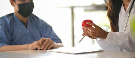 Cropped image of a male patient discussing and listening to a specialist doctor's diagnosis of his symptoms at a hospitalの写真素材