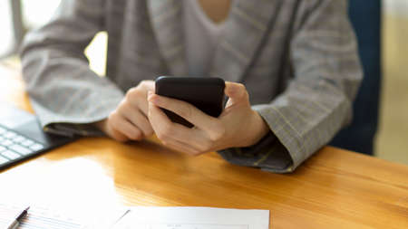 Young businesswoman using smartphone or cellphone to contact with business client, make an meeting appointment on mobile. close-upの写真素材