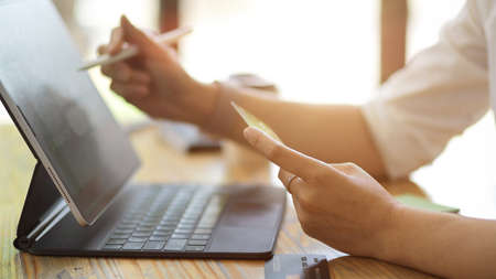 Side view, Close up woman's hands enter her credit card number and password on online shopping application via digital tabletの写真素材