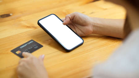 Female installed mobile internet banking app or connected banking account with application for transfer money. credit card on table. close-upの写真素材