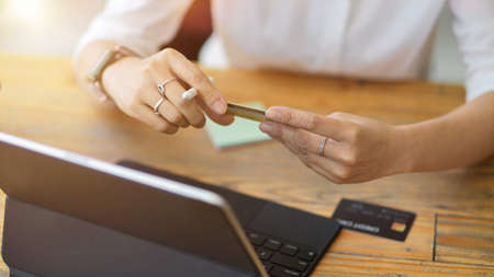 Modern technology in daily life concept, Woman sit at working desk with tablet and credit card. online paymentの写真素材