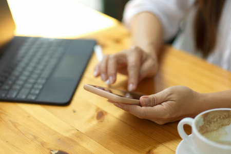 Close up, Female using smartphone for managing her agenda or to do list, relaxing on mobile phone applicationの写真素材