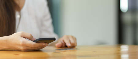 Cropped shot of Young female using smartphone, browsing internet, communicating on cellphone with a...