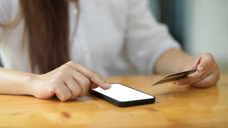 Close up, cropped shot millennial woman holding credit card and enter the details on smartphone application. online shopping, digital serviceの写真素材