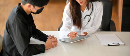 Cropped image of a female doctor or physician examining and following up on the patient's injury symptoms, and also making an appointment for the next visit.の写真素材
