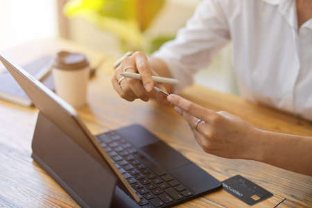 Close up Adult woman holding credit card for online shopping at home, e-commerce, modern technologyの写真素材
