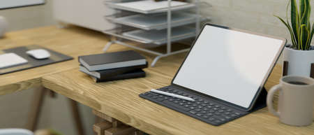Close-up of a modern work station interior design with a portable tablet screen mockup on a wooden table with office supplies. 3d illustration, 3d renderingの写真素材