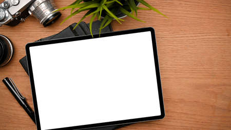 A Modern photographer desk with graphic tablet mockup for montage graphic on screen, camera and lens on wooden table. Top viewの写真素材