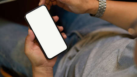 Close-up of a man holding smartphone and using on the website. mobile blank screen for montage