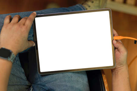 Tablet blank screen mockup in male hands. Male freelancer working on his digital tablet