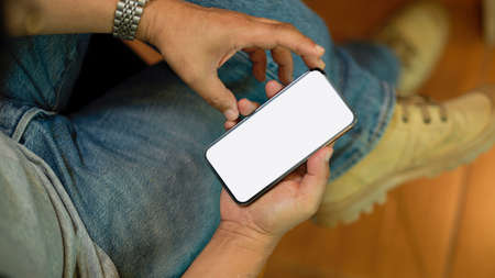Close-up Hipster male freelancer sitting in a cafe and using smartphone. mobile phone plank screen mockupの写真素材