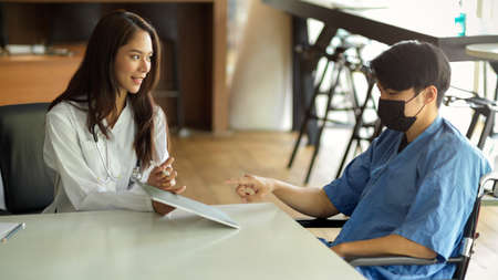 Asian female doctor diagnoses her male patient's disease and consults the treatment solutions plan...