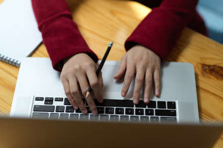 Closeup, Top view of business woman's hands typing on laptop keyboard, woking on portable laptop...