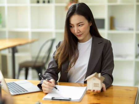 Professional female real estate agent making a renting contract document on paper in the officeの写真素材