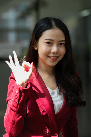 Portrait of Happy and confident  businesswoman showing ok hand sign in the office, ok positive gesture conceptの写真素材