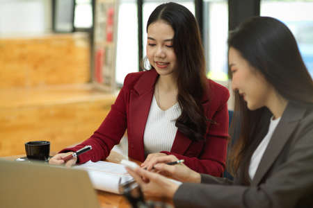 Two of young beautiful accountant estimate and calculate business statement for the next quarter. teamwork conceptの写真素材