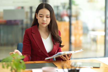 Focused and concentrated young business female working in the office, managing work and project.の写真素材