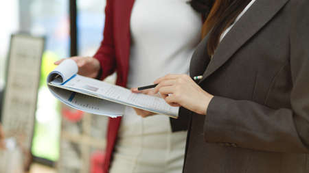 Cropped image, Business team members looking on data report papers and consult business solutions plan together in the office.の写真素材