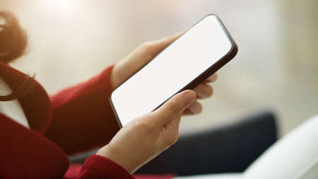Close-up Business women using modern smart mobile phone. phone blank screen mockup and blurred background. side view.の写真素材