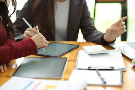 Cropped image of Success business female entrepreneur discuss a new launching product and plan marketing strategy together. tablet on the table.の写真素材