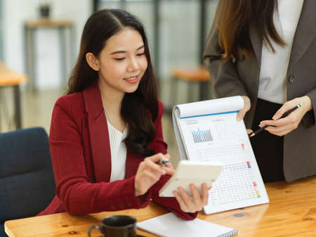 Young financial team presents financial results on a spreadsheet and graph chart in the meetingの写真素材
