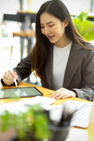 Portrait of asian businesswoman consultant working in her modern office, working on portable tablet computer.の写真素材
