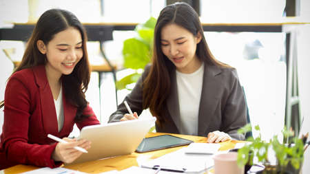 Beautiful professional Asian businesswoman giving business advice to her coworkers in the office. teamwork, co-worker meeting for new project.の写真素材