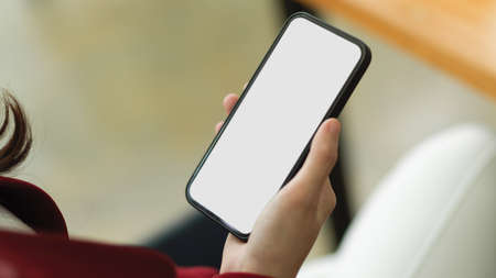 Close-up Business women holding smartphone, smartphone white blank screen mockup with blurred background. mobile phone, cellphone, device.の写真素材