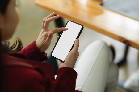 Closeup executive business woman using smartphone at her working desk in board room, smartphone blank screen mockup.の写真素材