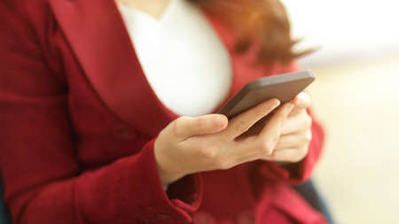 Close-up of Successful business entrepreneur using modern smart mobile phone in her office.の写真素材