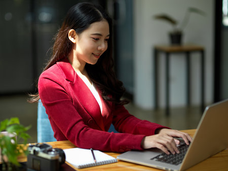 Close up portrait of successful asian businesswoman in formal outfit working on laptop computer. on online business webinar meeting.の写真素材
