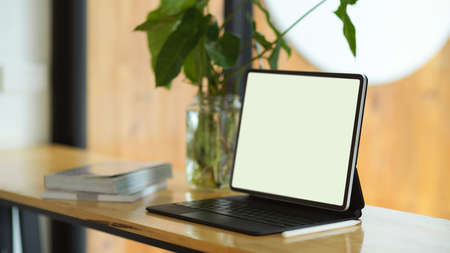 Digital tablet blank screen mockup with keyboard stand on portable work table in a cafeの写真素材